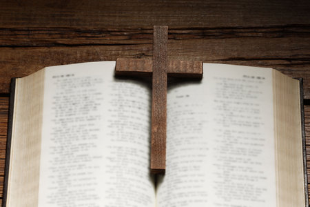 Bible and cross on wooden table, above view. Religion of Christianity