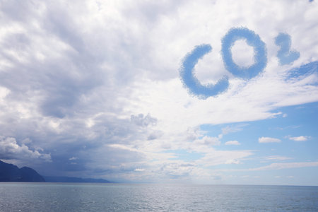 Blue sky with CO2 chemical formula and clouds over sea. Carbon dioxide emissionsの写真素材