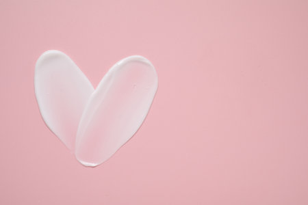 Face cream on pink background, top view. Space for textの写真素材