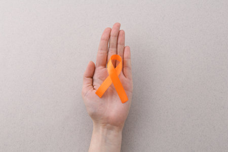 Woman with orange awareness ribbon on gray background, top viewの写真素材