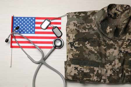 Stethoscope, USA flag, tags and military uniform on white wooden table, flat layの写真素材