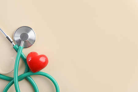 Stethoscope and red heart on beige background, top view. Space for textの写真素材