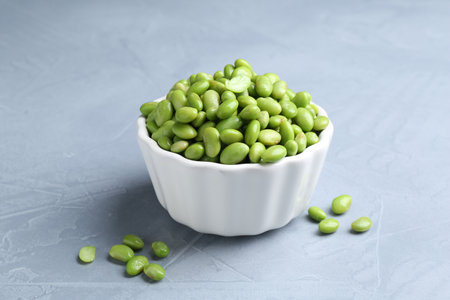 Fresh edamame soybeans in bowl on gray textured table, closeupの写真素材