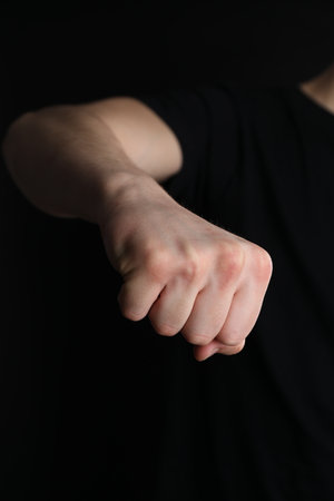Man showing fist with space for tattoo on black background, closeupの写真素材