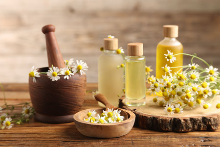 Different flowers and bottles of essential oils on wooden tableの写真素材
