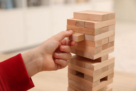 Child playing wooden blocks at table indoors, closeupの写真素材