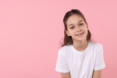 Portrait of happy girl on pink background, space for textの写真素材