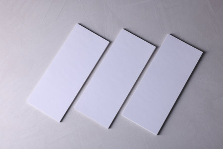 Blank business cards on light grey textured background, top view. Mockup for designの写真素材