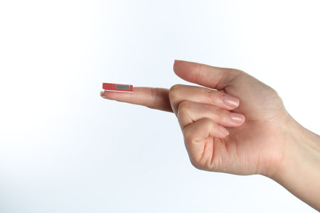 Woman with SIM card on white background, closeupの写真素材