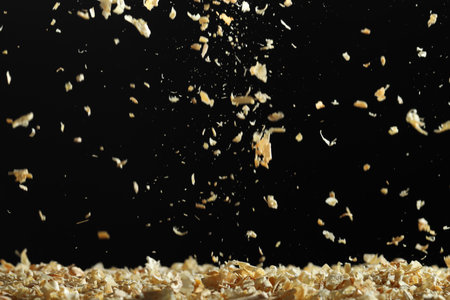 Dry natural sawdust falling on black backgroundの写真素材