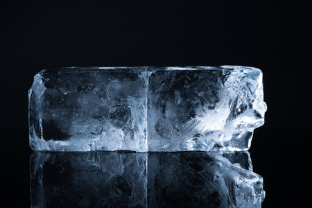 Blocks of clear ice on black mirror surfaceの写真素材