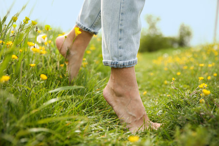 Woman walking barefoot on green grass outdoors, closeupの写真素材