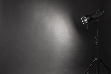 Dark photo background and professional lighting equipment in studio. Space for text