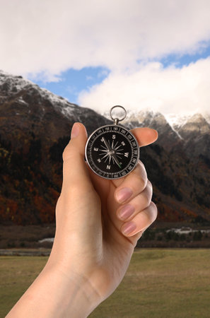 Woman using compass in mountains, closeup. Navigational instrumentの写真素材