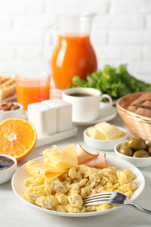 Tasty breakfast. Scrambled eggs, ham, cheese and other food served on light table, closeupの写真素材