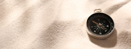 Compass on sand. Banner design with space for text