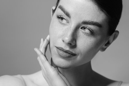 Attractive woman on grey background. Fashionable black and white portrait