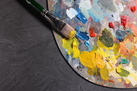 Artist's palette, brush and paints on gray table, top view. Space for textの写真素材