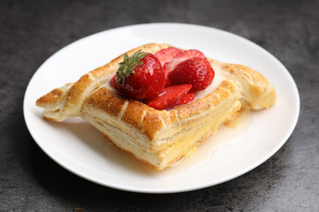 Tasty puff pastry with strawberries on gray table, closeupの写真素材