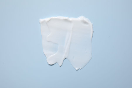 Face cream on light blue background, top viewの写真素材