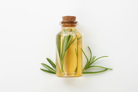 Bottle with essential oil and rosemary on white background, top viewの写真素材