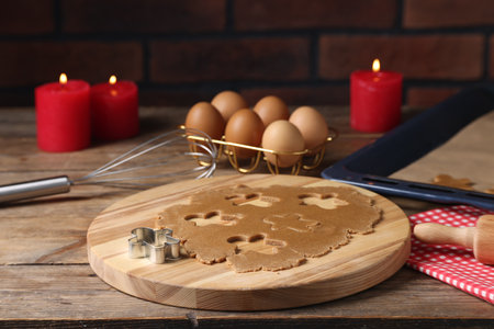 Raw dough, cookie cutter, whiskey, eggs and burning candles on wooden table