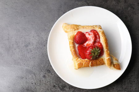 Tasty puff pastry with strawberries on gray table, top view. Space for textの写真素材