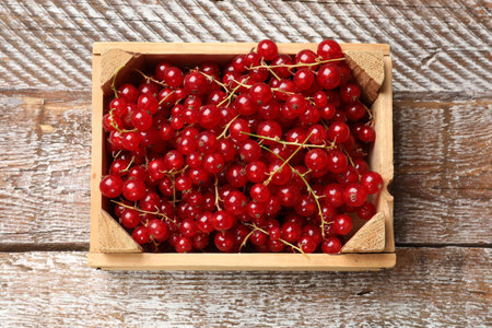 Fresh red currants in crate on wooden table, top viewの写真素材