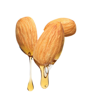 Oil dripping from almonds on white backgroundの写真素材