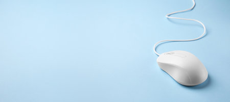 Computer mouse on light blue background. Banner design with space for textの写真素材