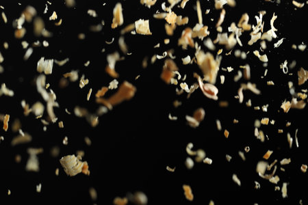 Dry natural sawdust falling on black background