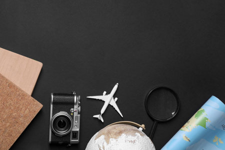 Travel blogger. Flat lay composition with vintage camera on black background, space for textの写真素材