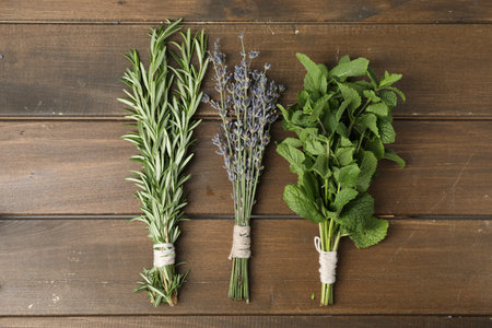 Bunches of different aromatic herbs on wooden table, flat layの写真素材