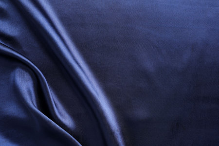 Crumpled dark blue silk fabric as background, top view. Space for textの写真素材
