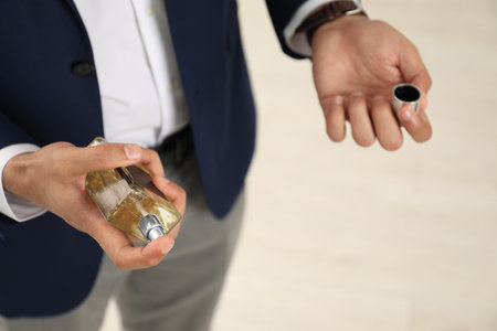 Young man spraying luxury perfume indoors, closeupの写真素材