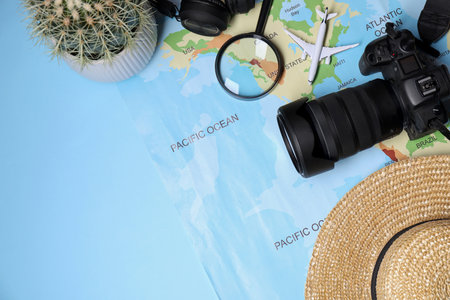 Travel blogger. Flat lay composition with camera and map on light blue backgroundの写真素材