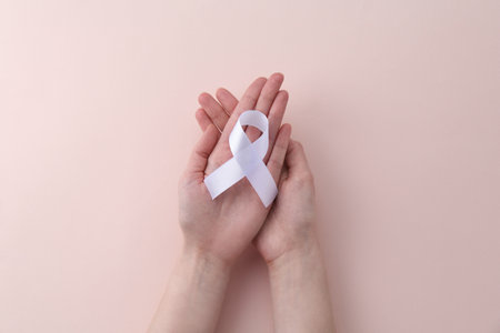Woman with white awareness ribbon on beige background, top viewの写真素材