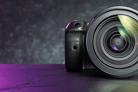 Modern photo camera on black table, space for textの写真素材