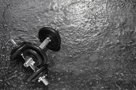 Barbells on dark textured floor, top view. Space for textの写真素材