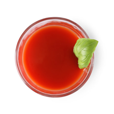 Tasty tomato juice in glass and basil isolated on white, top viewの写真素材