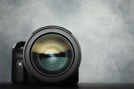 Modern photo camera on black table, space for textの写真素材