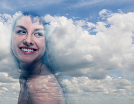 Happy woman and beautiful sky with clouds, double exposureの写真素材