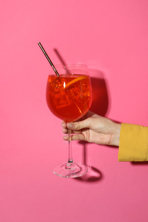 Woman with glass of refreshing cocktail on pink background, closeupの写真素材