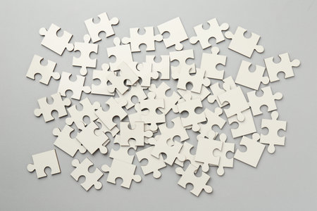 White puzzle pieces on gray background, top viewの写真素材