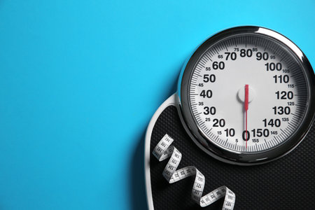 Scale and measuring tape on light blue background, top view. Space for textの写真素材