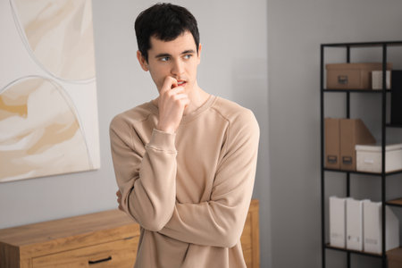 Portrait of embarrassed young man in office