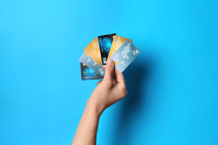 Man holding credit cards on light blue background, closeupの写真素材