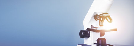 Microscope on blue background, closeup. Banner design with space for text