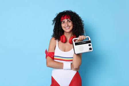 Aerobics. Happy woman with radio receiver on light blue background