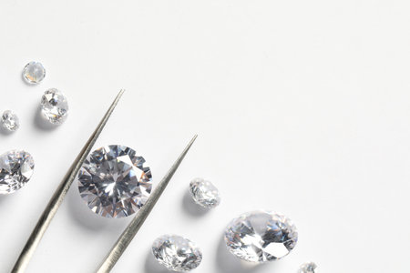 Many beautiful shiny diamonds and tweeters on white background, flat lay. Space for text